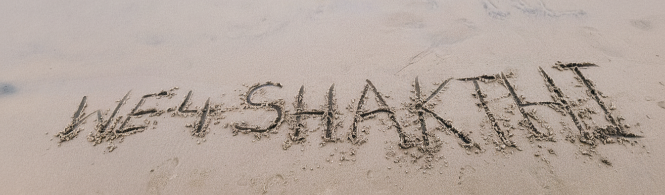 WE4Shakthi written on sand